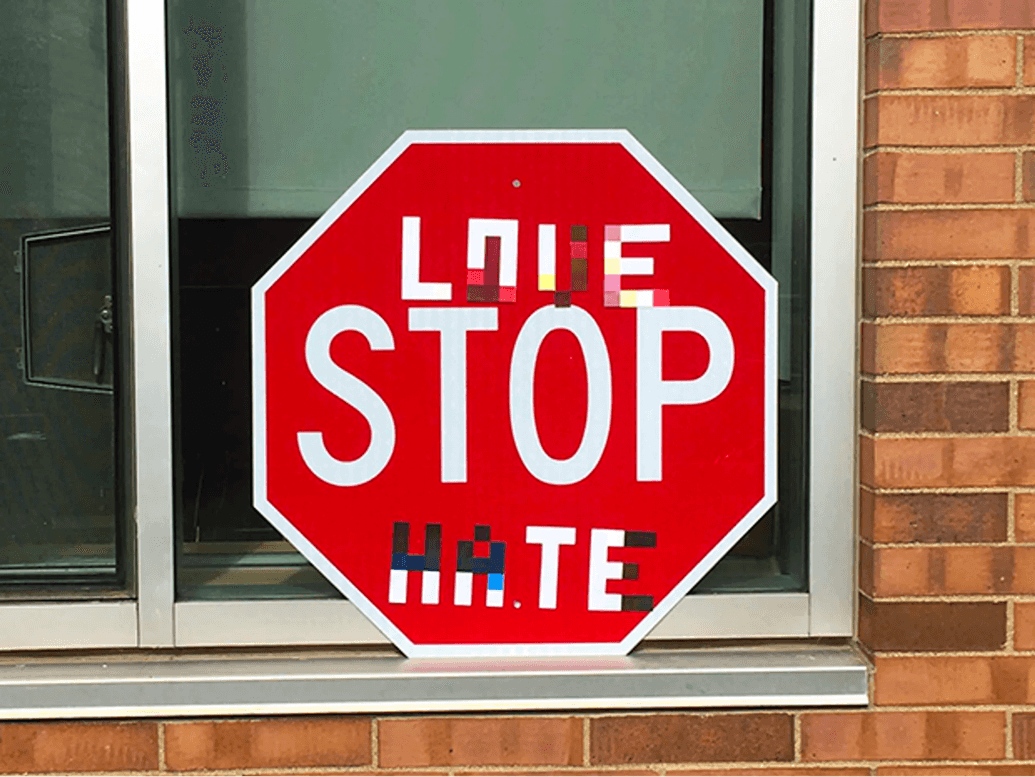 A stop sign that has been written over to read “Love STOP hate